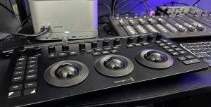 Primary Blackmagic design editing control surface with three large jog wheels and labeled function buttons in a studio setup.